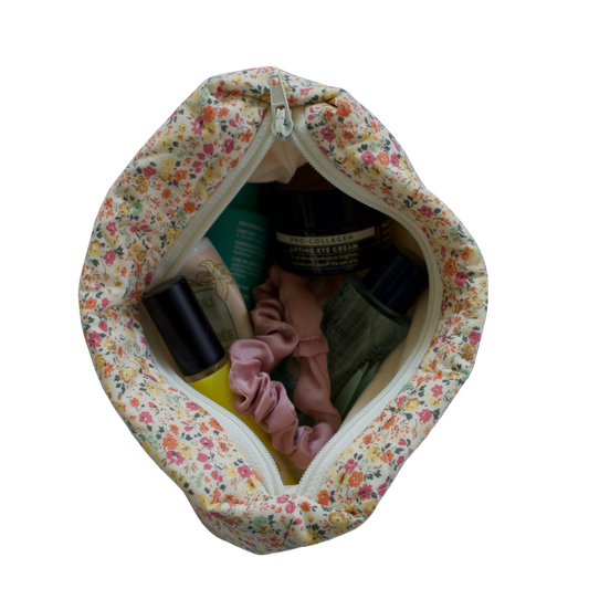 Floral-patterned baby care bag with items inside on a white background mini pouch