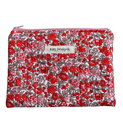 Floral patterned pouch with 'Kitt Designs' label zipper pouch