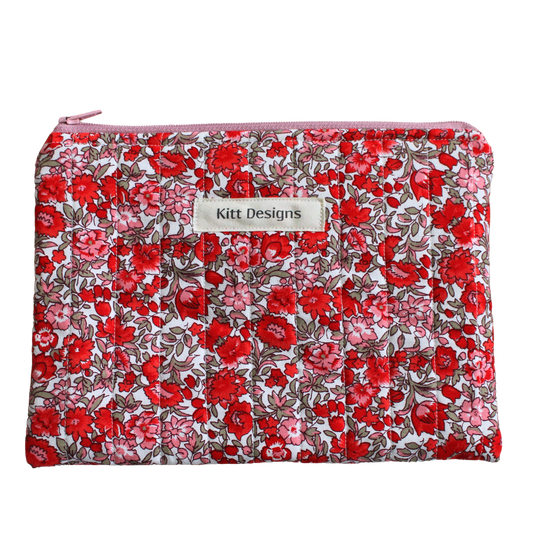 Floral patterned pouch with 'Kitt Designs' label zipper pouch