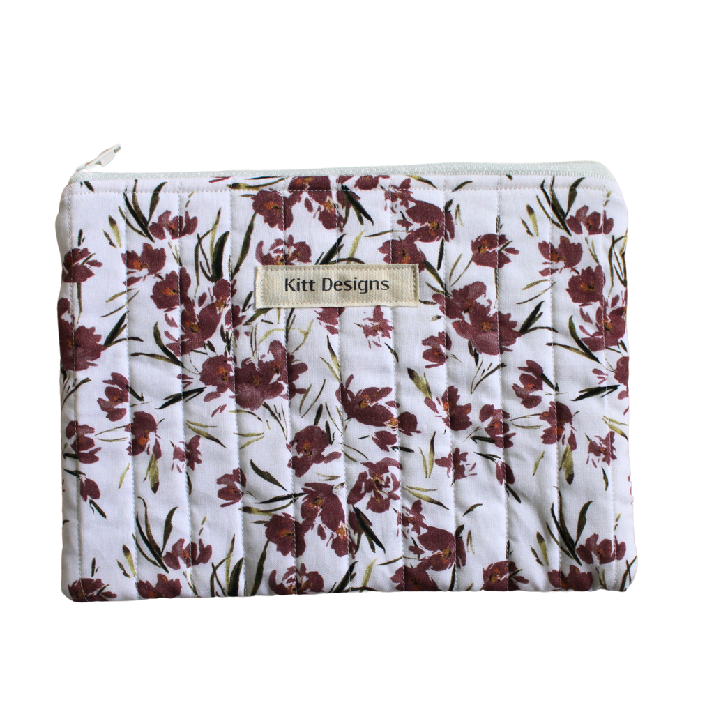 Floral-patterned pouch with 'Kitt Designs' branding zipper pouch