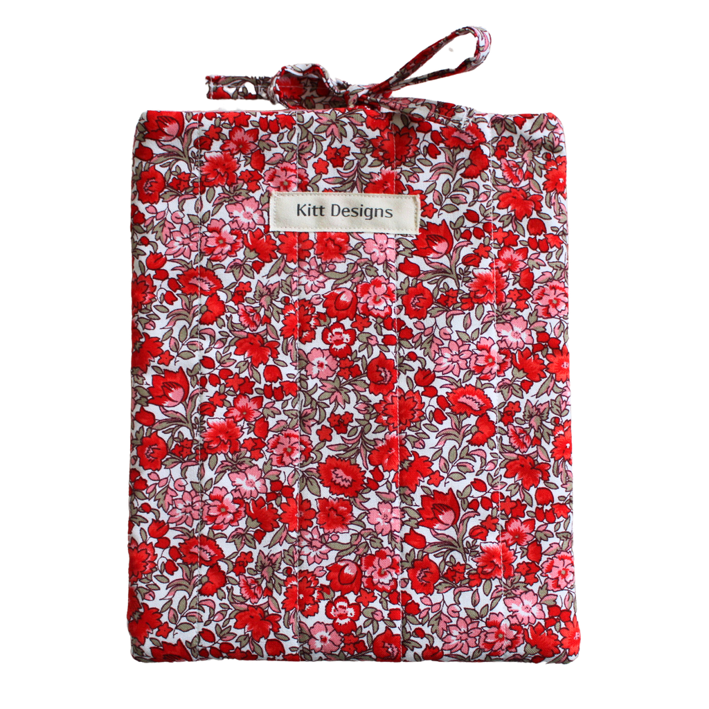 Floral-patterned fabric roll with a visible brand label small book sleeve