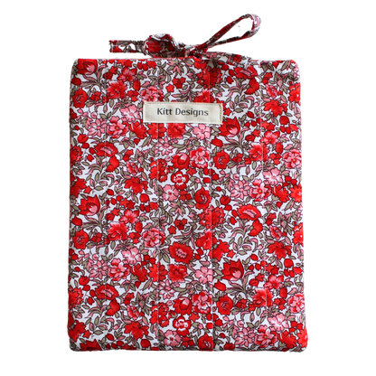 Floral-patterned fabric roll with a visible brand label small book sleeve