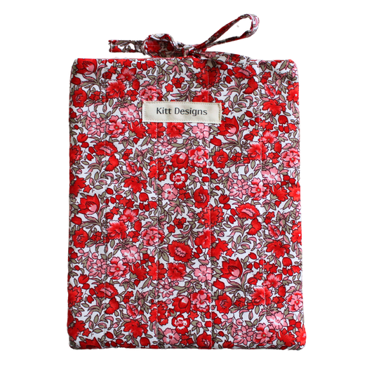 Floral-patterned fabric roll with a visible brand label small book sleeve