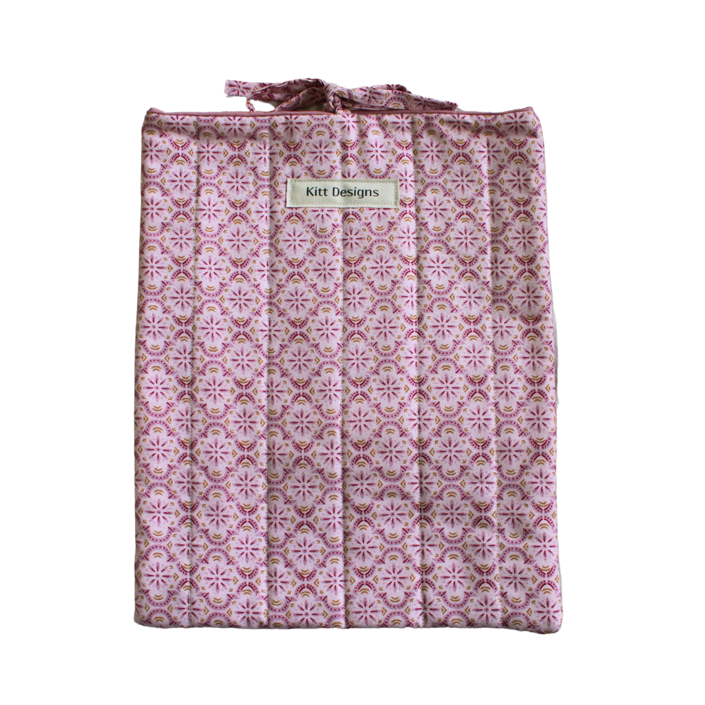 Pink patterned bag with a visible brand label large book sleeve