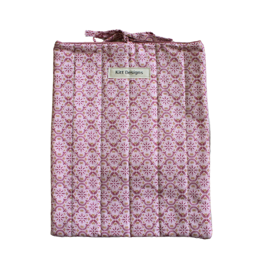 Pink patterned bag with a visible brand label large book sleeve