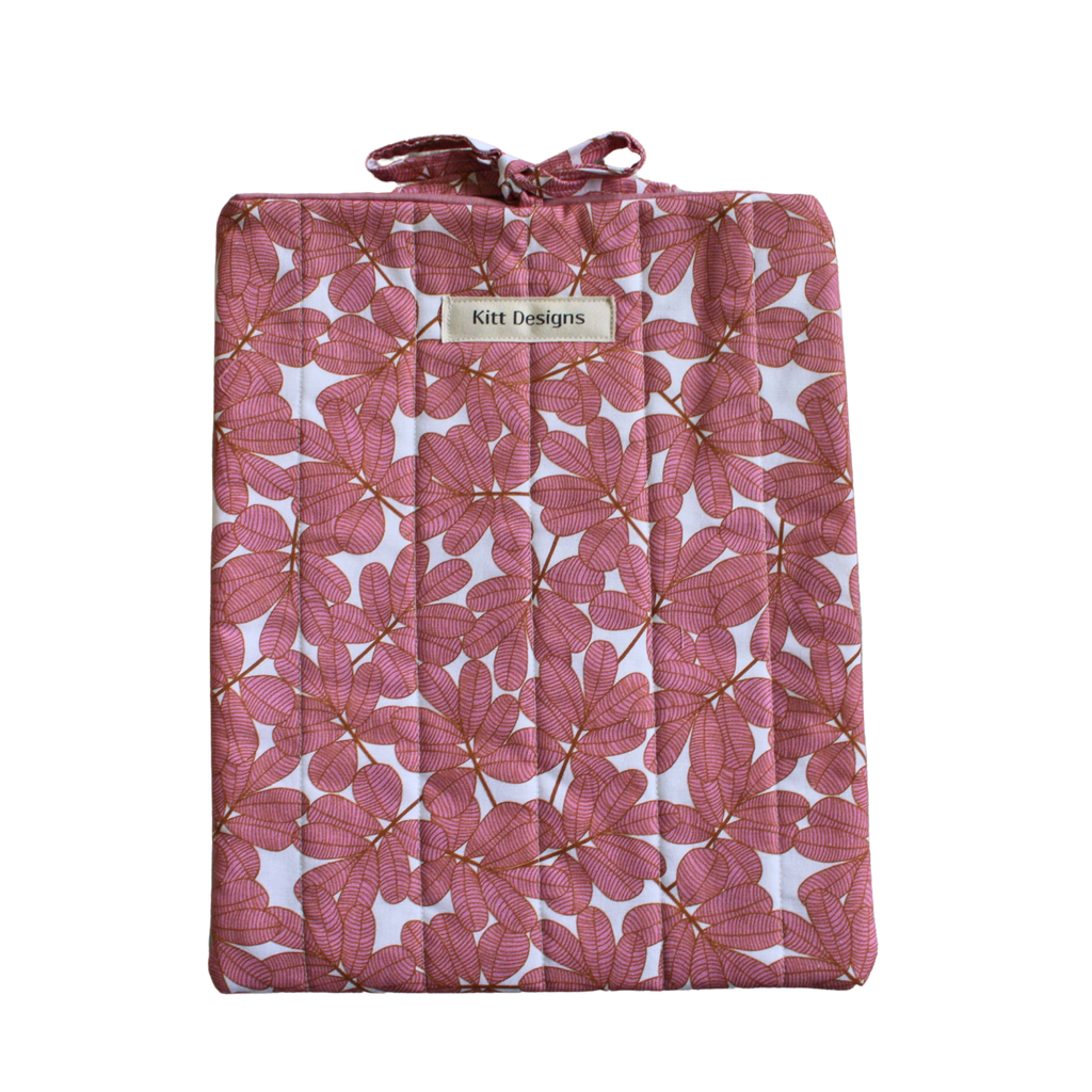 Pink floral-patterned quilt with a brand label large book sleeve