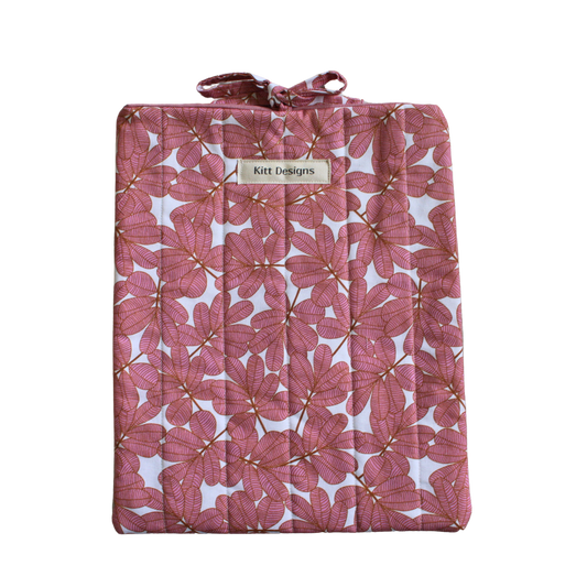 Pink floral-patterned quilt with a brand label large book sleeve