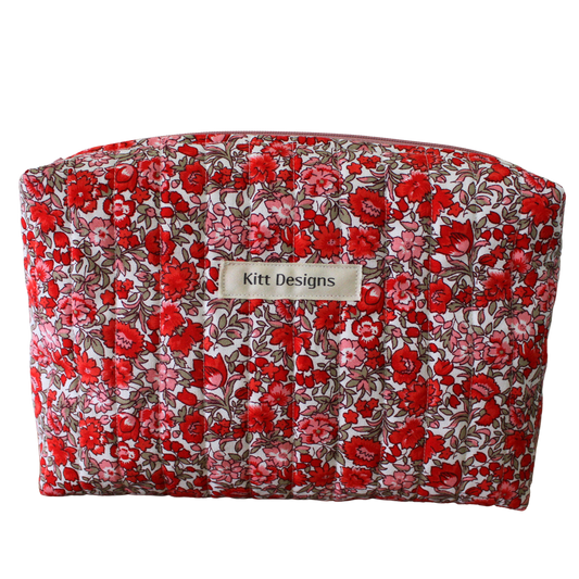 Floral-patterned makeup bag with 'Kitt Designs' label beauty pouch