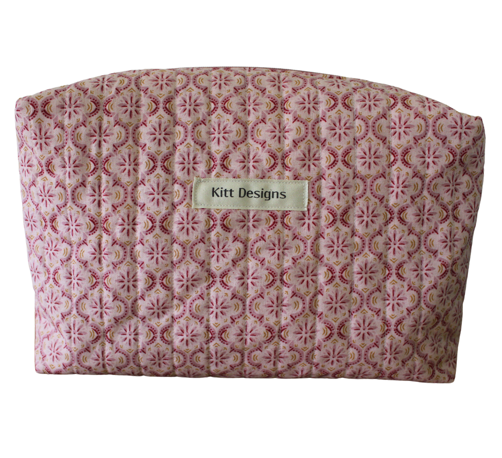 Patterned pouch with 'Kitt Designs' label travel pouch