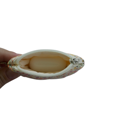 Small pouch held by a hand on a white background