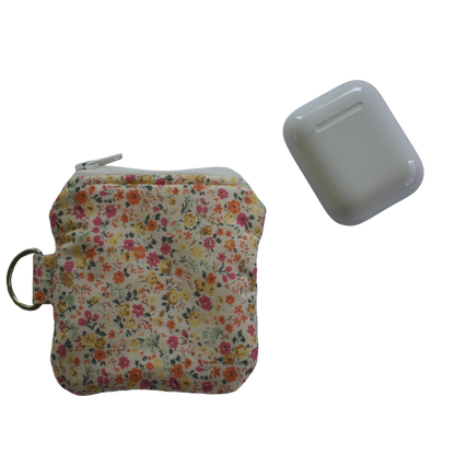 Floral-patterned pouch with a keychain and a small rectangular item on a white background