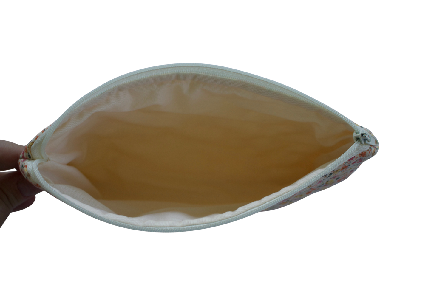 Hand holding a leaf-shaped pouch with a yellowish-brown interior on a white background zipper pouch