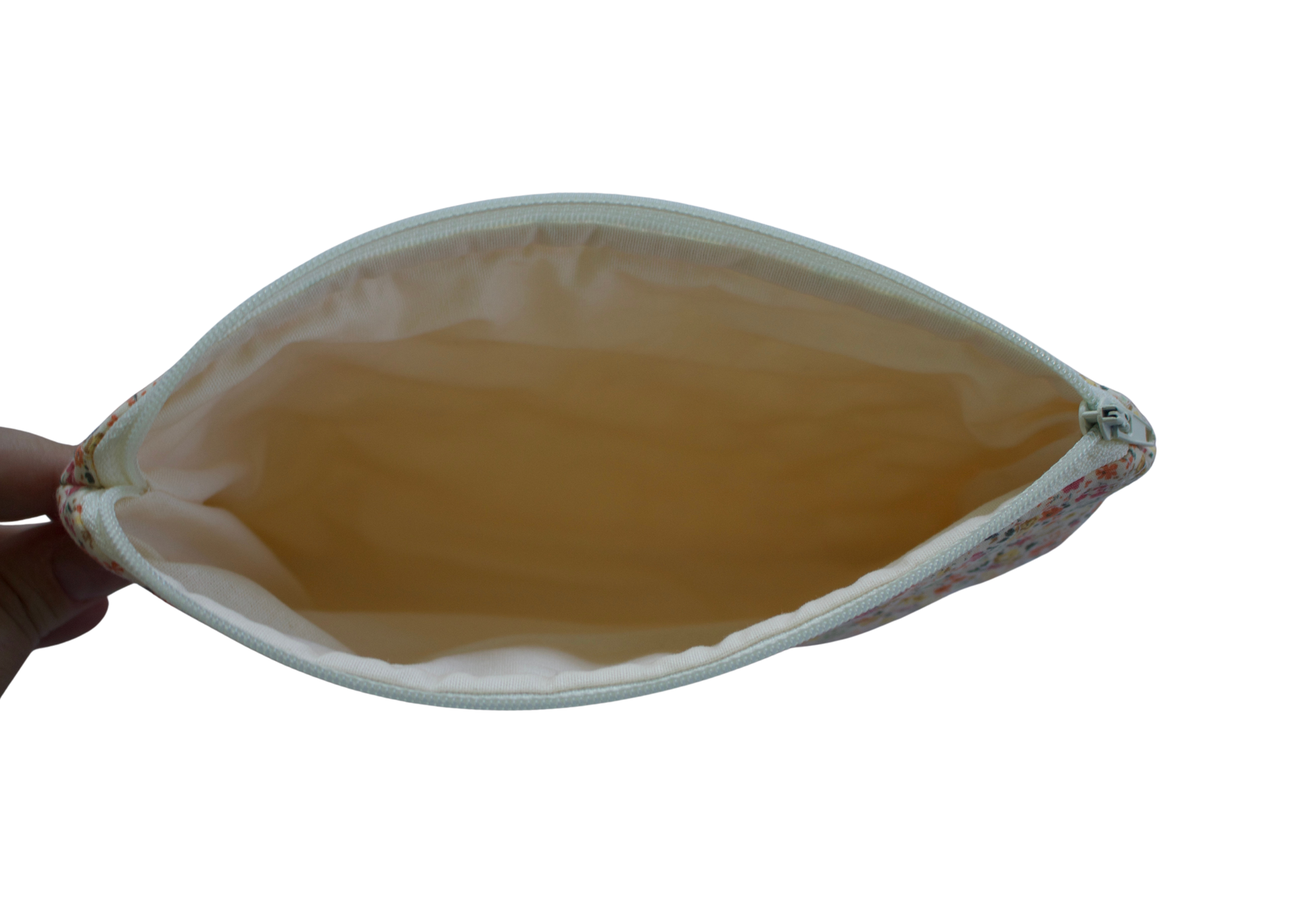 Hand holding a leaf-shaped pouch with a yellowish-brown interior on a white background zipper pouch