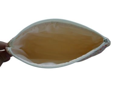 Hand holding a leaf-shaped pouch with a yellowish-brown interior on a white background zipper pouch