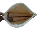 Makeup brushes in a white pouch held by a hand on a white background zipper pouch