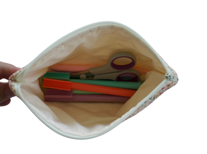 Pouch with colorful items including scissors and straws on a white background zipper pouch