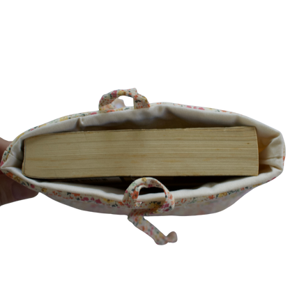 Fabric pouch with a book inside on a white background small book sleeve