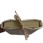 Book wrapped in fabric with a ribbon on a white background small book sleeve