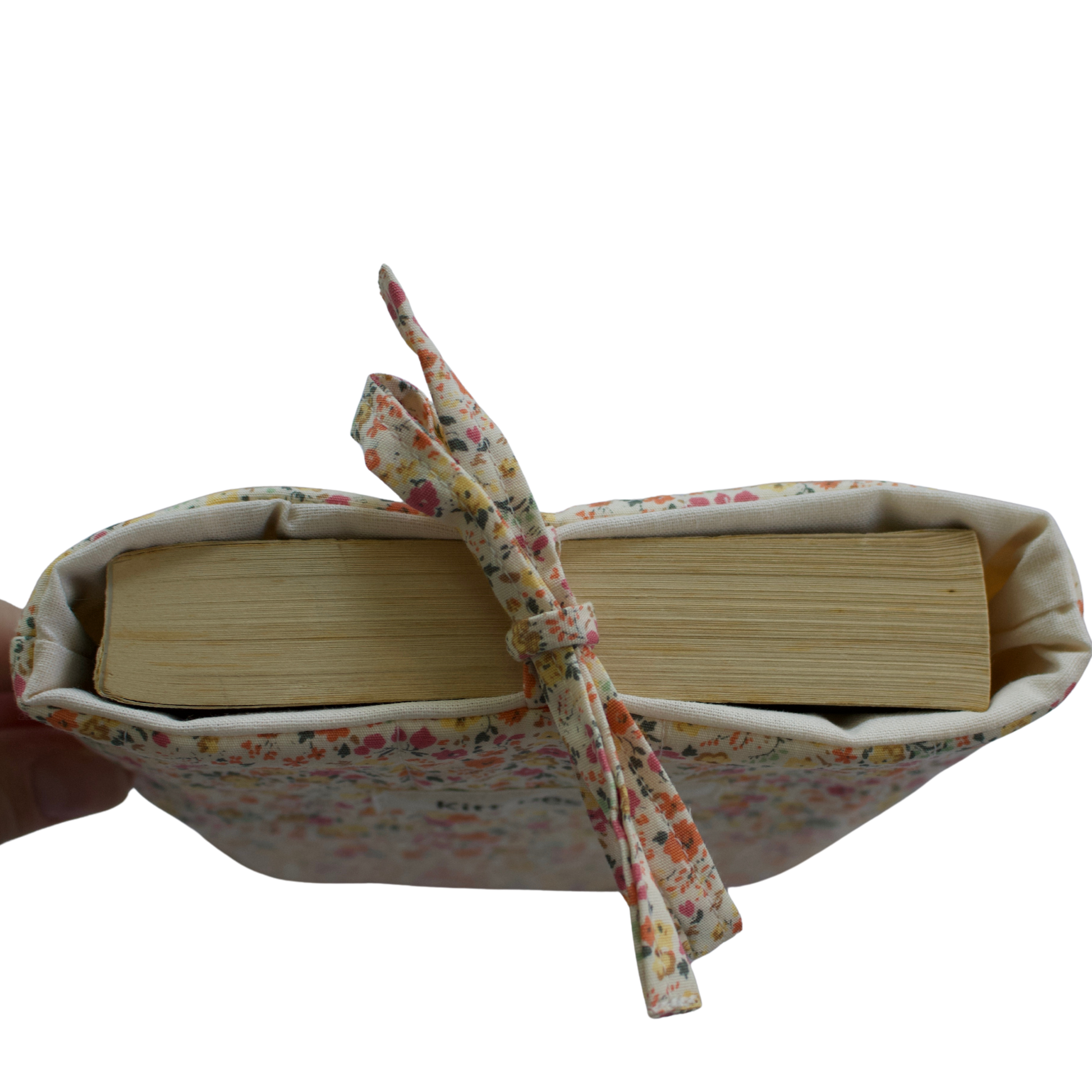 Book wrapped in fabric with a ribbon on a white background small book sleeve