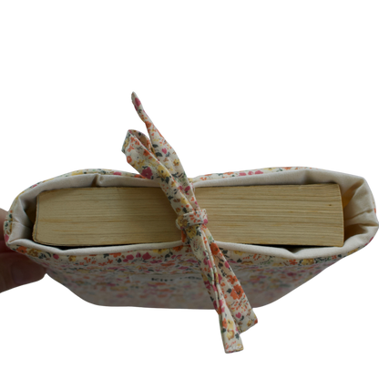 Book wrapped in fabric with a ribbon on a white background small book sleeve