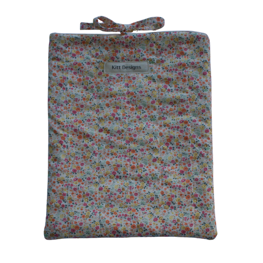 Floral-patterned pouch with a strap on a white background for books