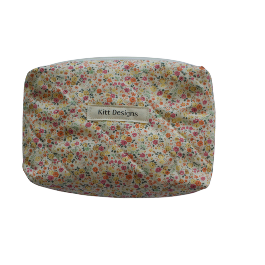 Floral patterned pouch with 'Kitt Designs' label on a white background mini pouch