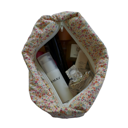 Floral-patterned travel bag with toiletries on a white background travel pouch
