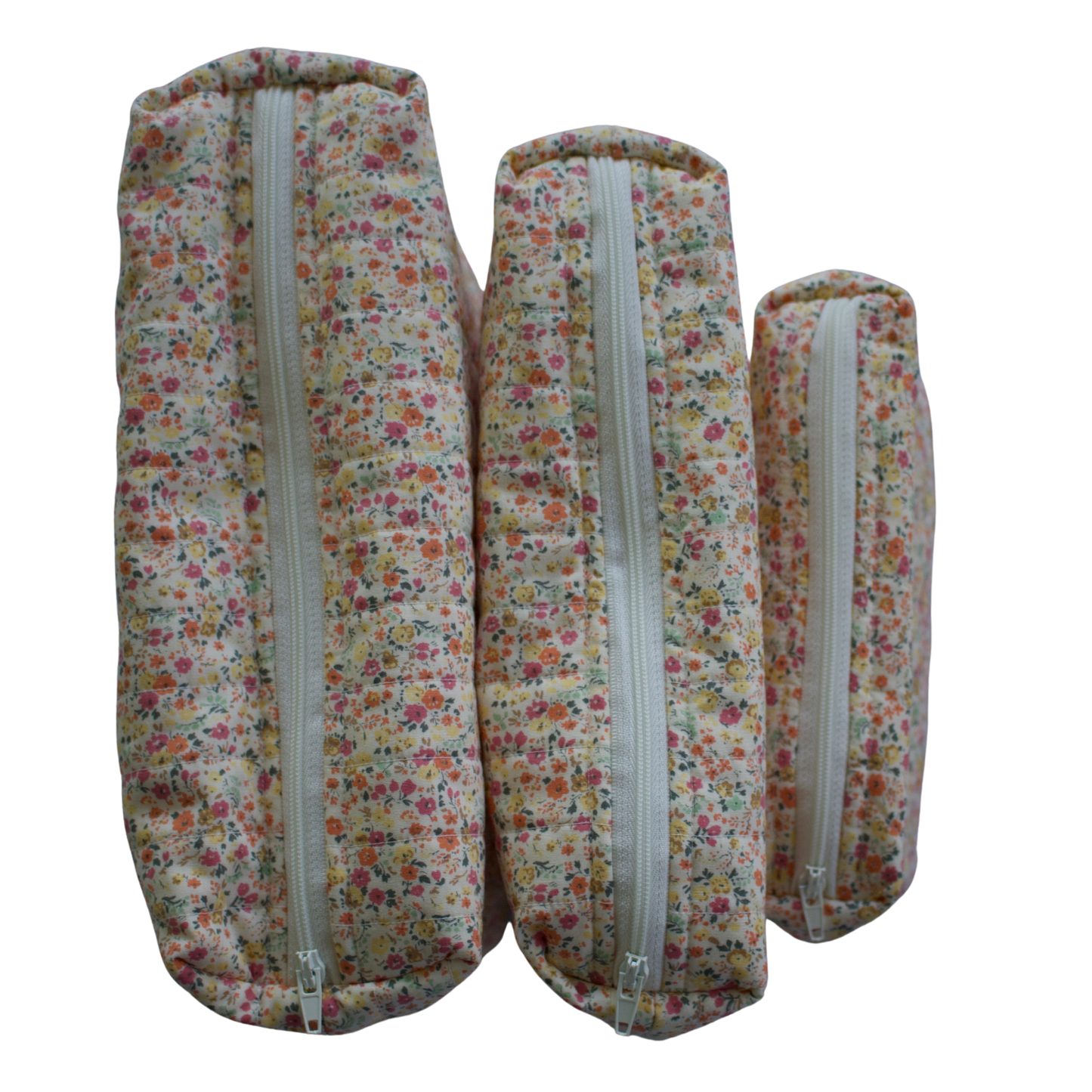 Three floral-patterned fabric rolls with zippers on a white background