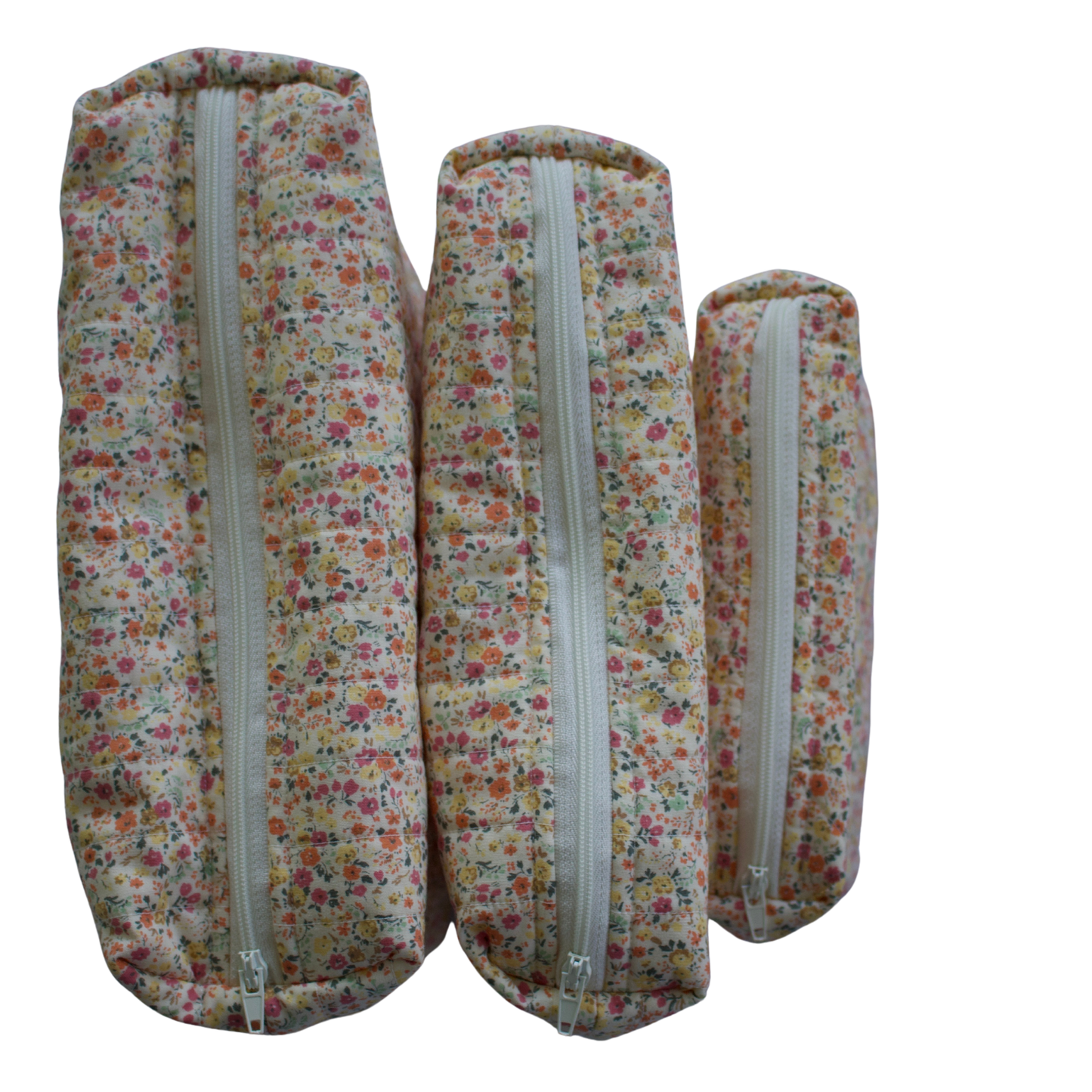 Three floral-patterned fabric rolls with zippers on a white background