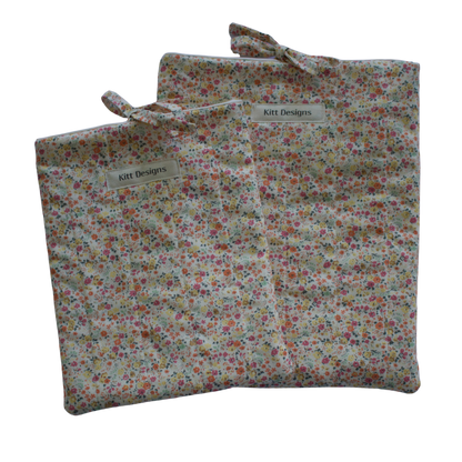 Floral-patterned fabric bag with a visible brand label on a white background