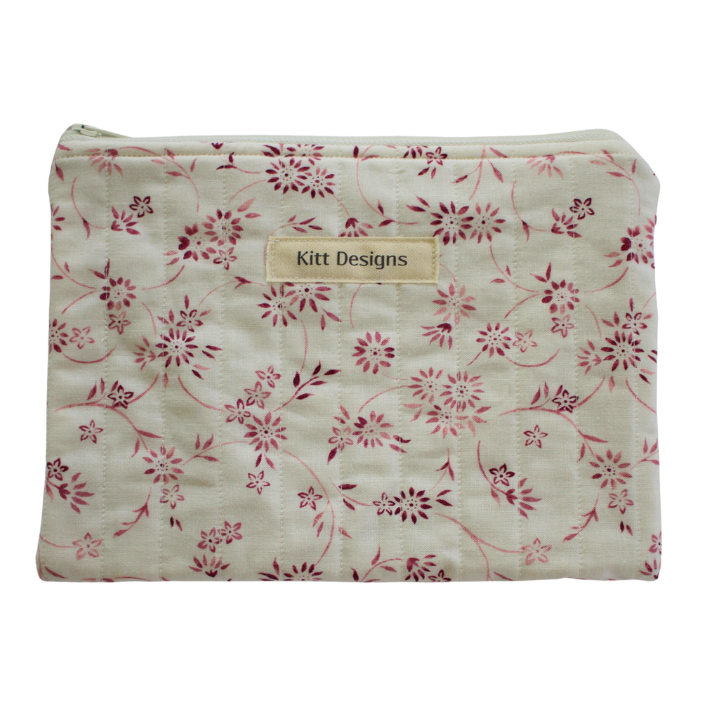 Floral-patterned pouch with 'Kitt Designs' label zipper pouch