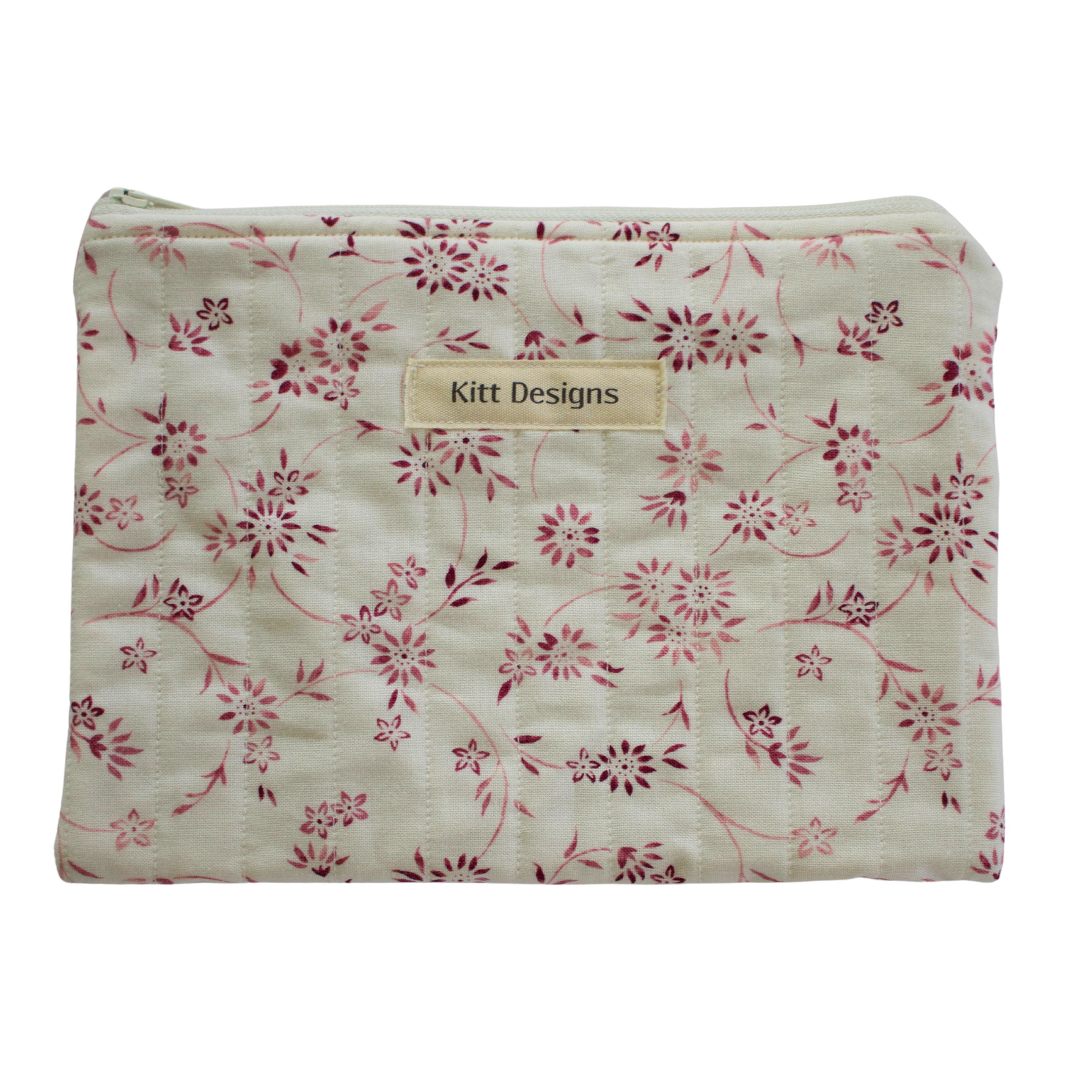 Floral-patterned pouch with 'Kitt Designs' label zipper pouch
