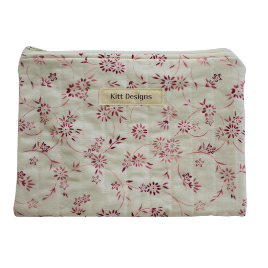 Floral-patterned pouch with 'Kitt Designs' label zipper pouch