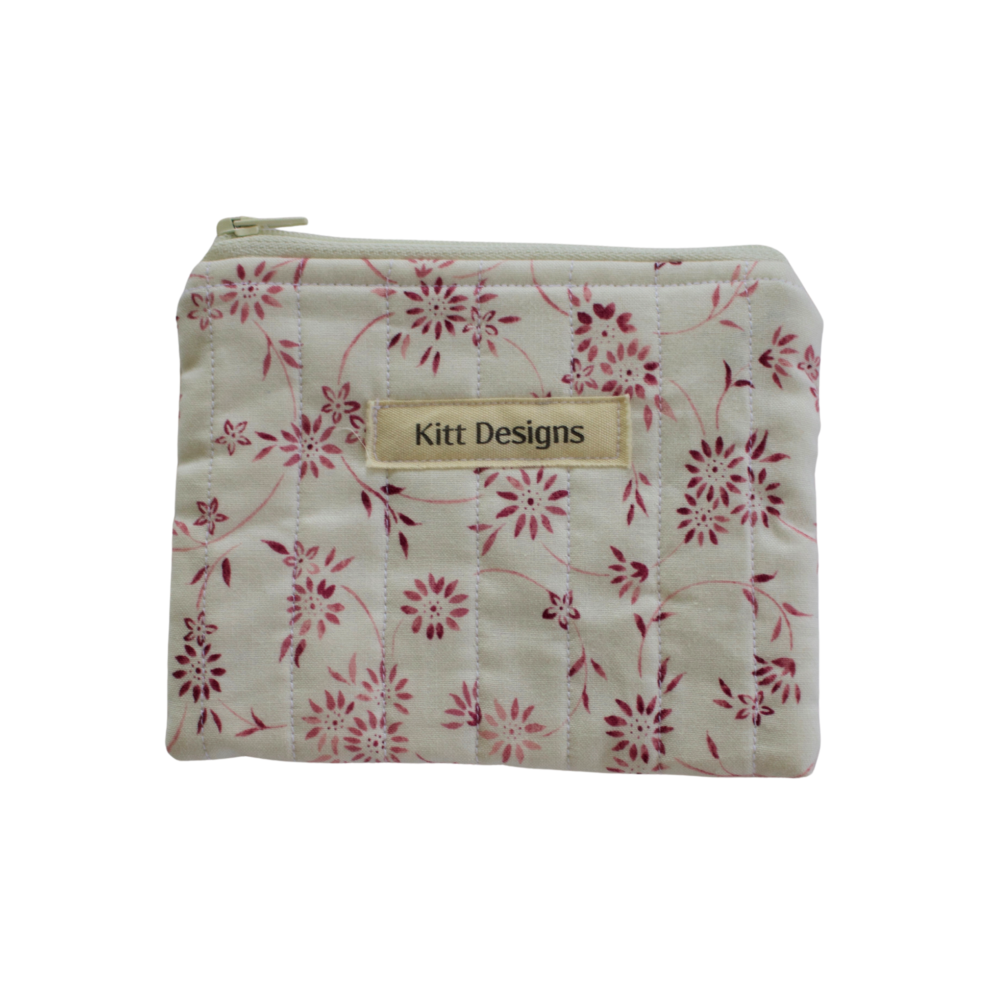Floral-patterned pouch with 'Kitt Designs' label coin pouch