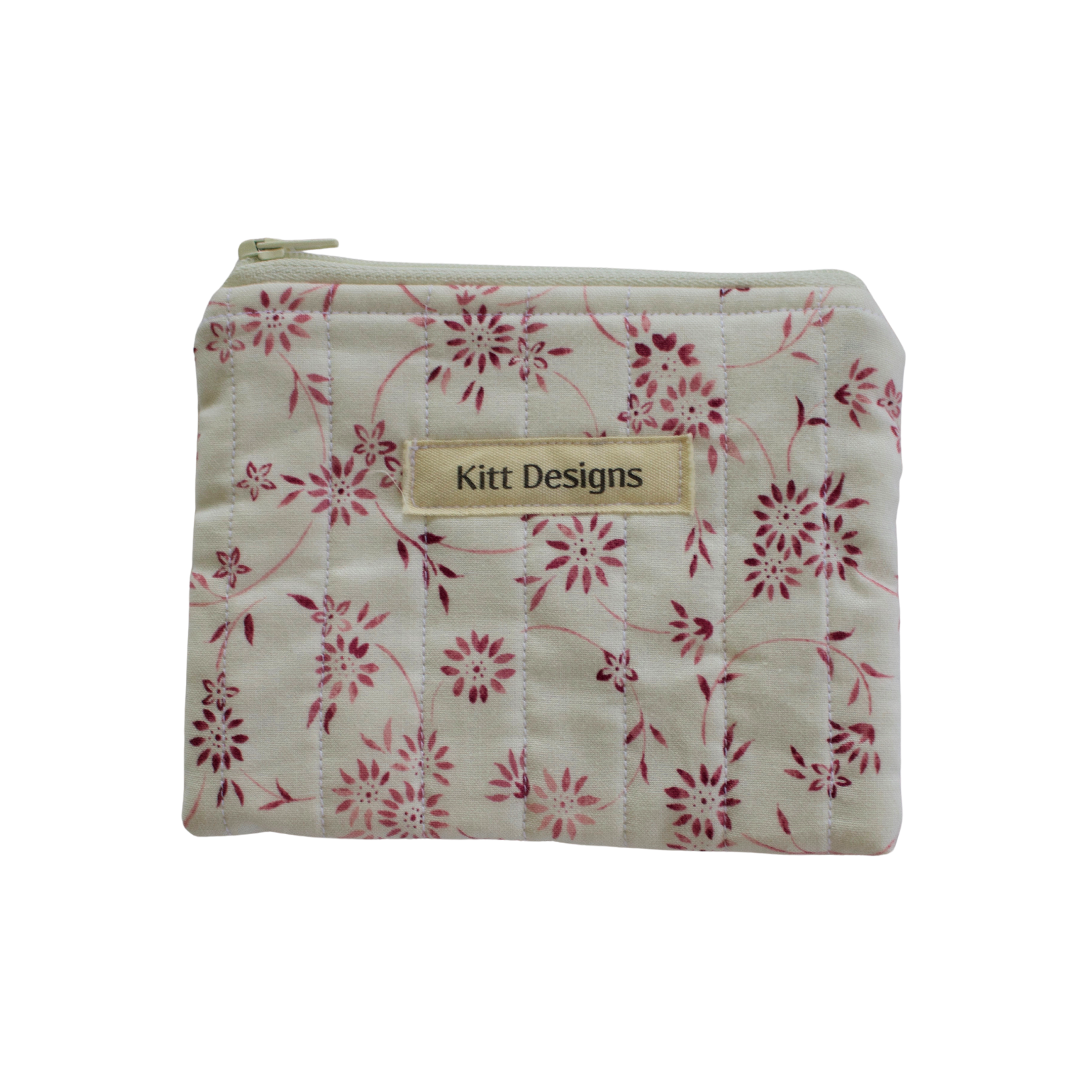 Floral-patterned pouch with 'Kitt Designs' label coin pouch