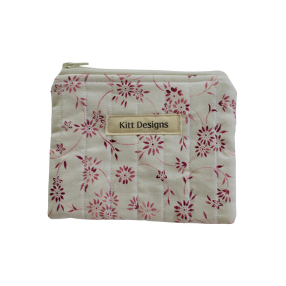 Floral-patterned pouch with 'Kitt Designs' label coin pouch