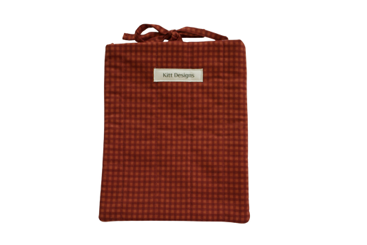 Red checkered pouch with a brand label small book sleeve