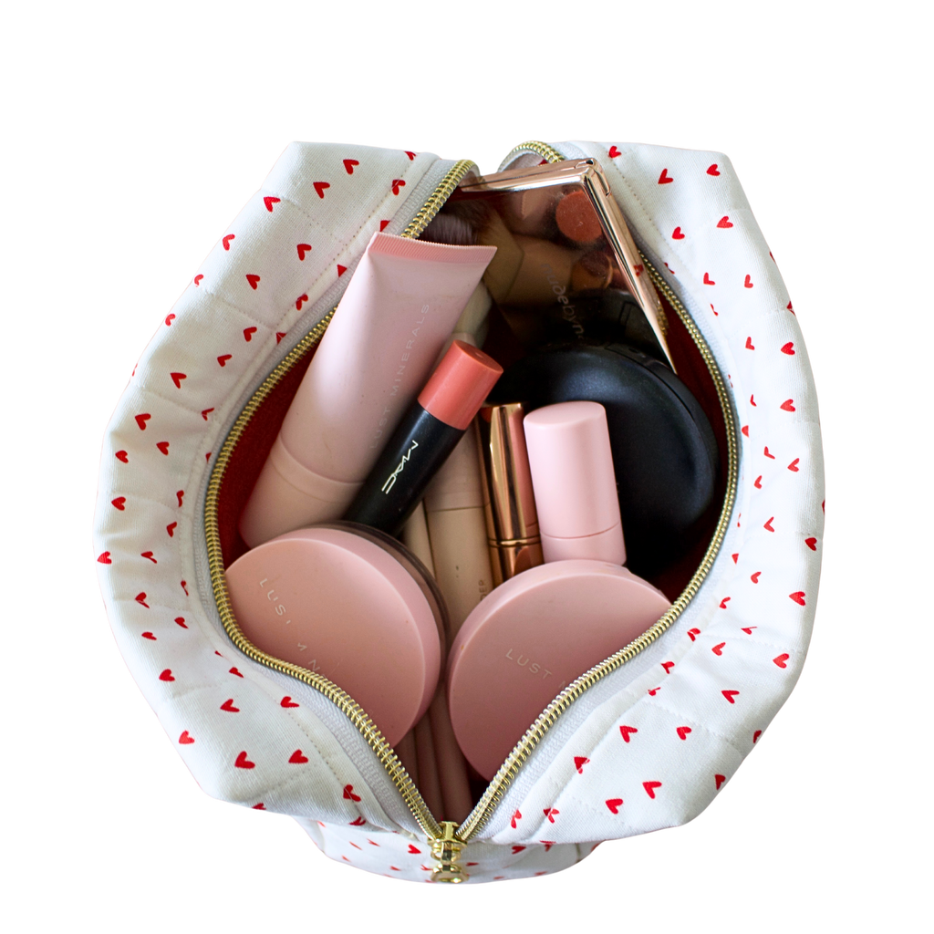 An open white cosmetic pouch with a red heart pattern and gold zipper, shown from a top-down view on a white background. Makeup bag. Handmade Makeup pouch. Handmade quilted pouch