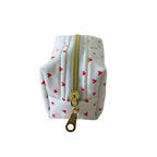 A small white fabric pouch with a repeating pattern of small red hearts and a gold zipper, shown on a plain white background.